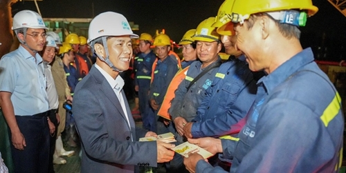 Chairman of the Provincial People s Committee Nguyen Van Phuong encourages workers building the Huong River Overpass