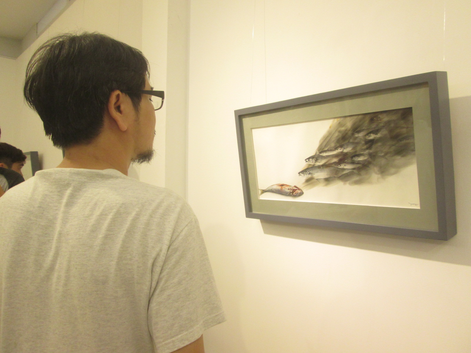 Một người xem đang thưởng thức tác phẩm hội họa của Phan Vũ Tuấn