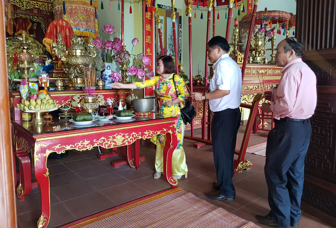 Visitors offer incense to commemorate Hung Kings at the temple located in the tourism village