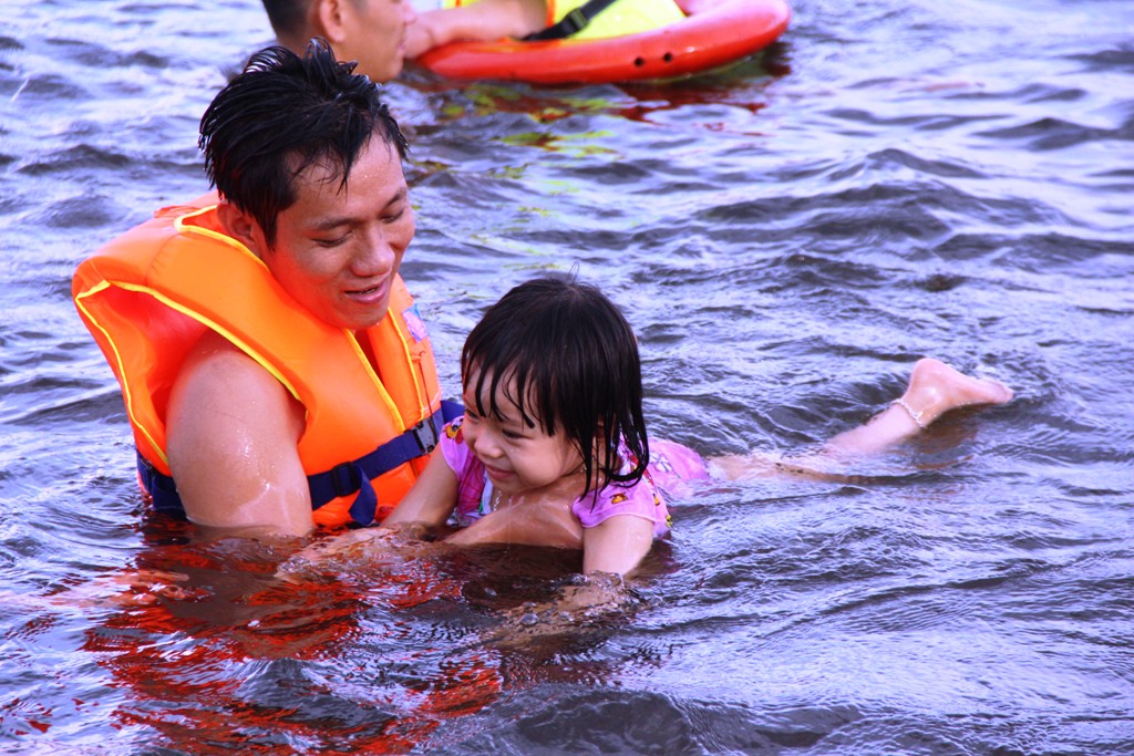 Meanwhile, a little girl looks happy when her father teaches her to swim
