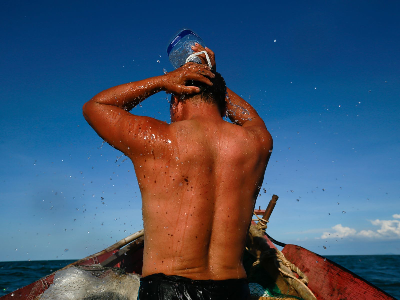 After the boat is anchored at the squid fishing spot, Mr. Tam baths with fresh water, preparing bait and having his dinner, preparing for an overnight of work.