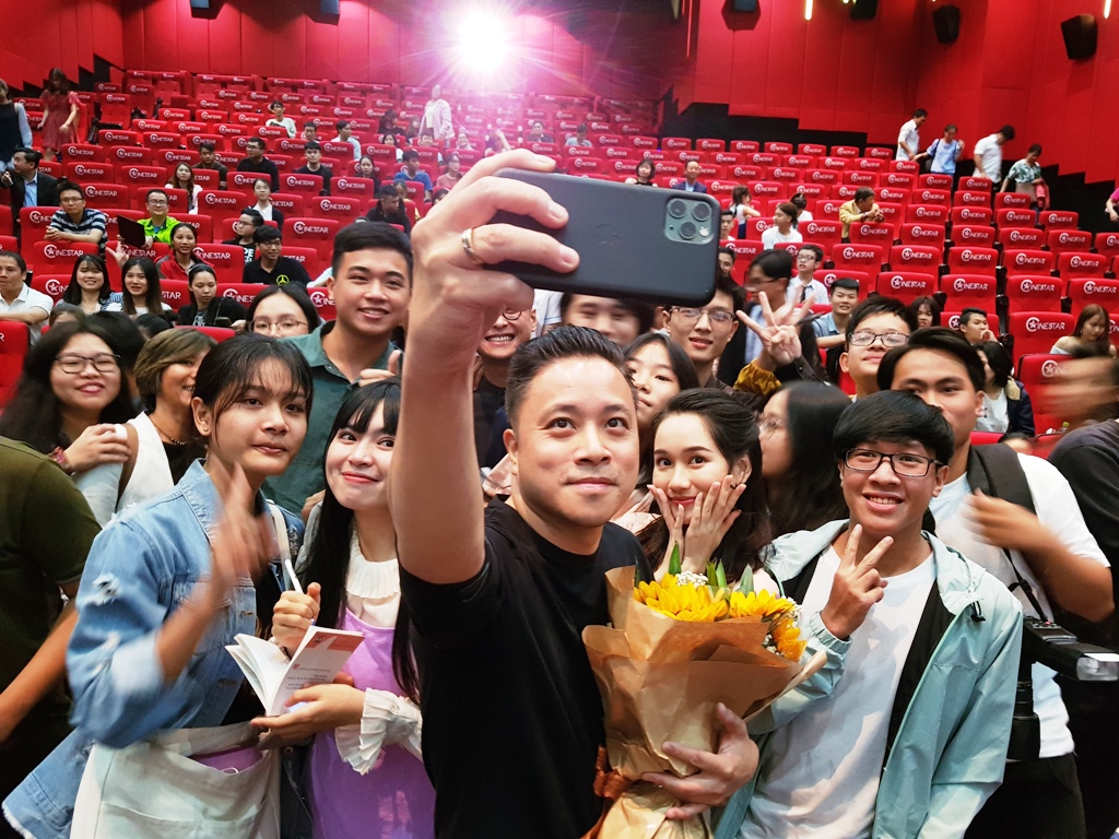 Victor Vu, the director of the film Dreamy Eyes taking a photo with fans