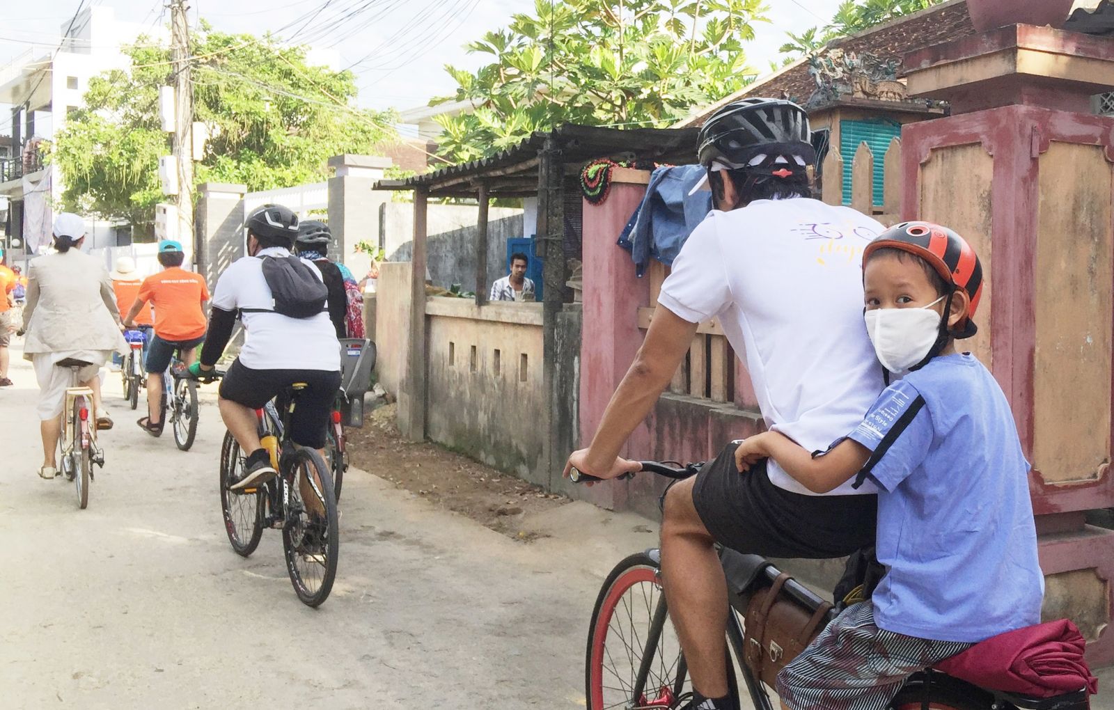 Although some children cannot cycle by themselves, they still go with their father in calling for environmental protection