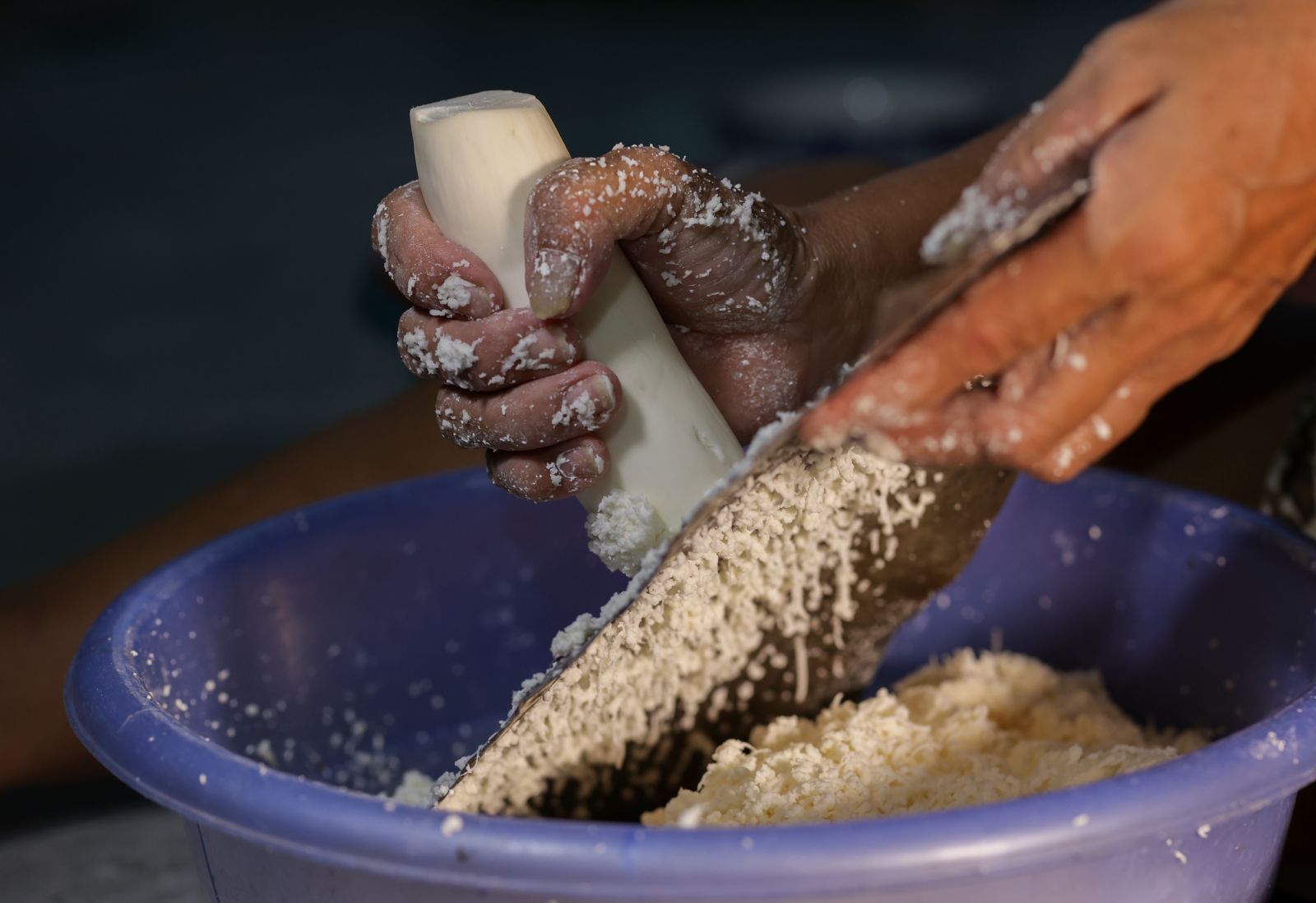 Grinding cassava by hand is very laborious