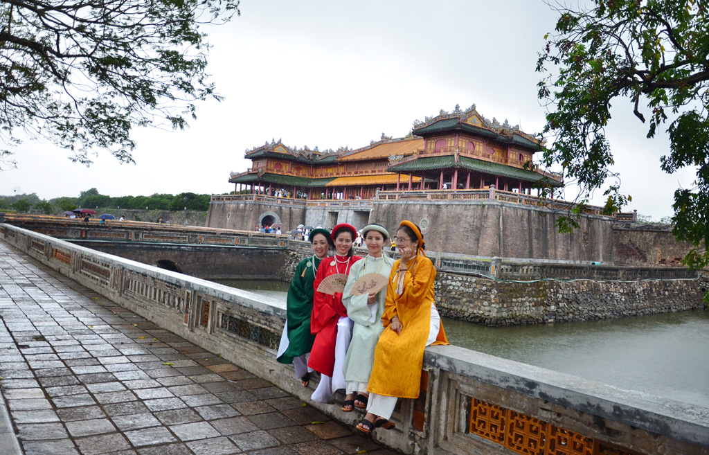 Many female tourists choosing five-panel Ao dai to have photos taken in the heritage space