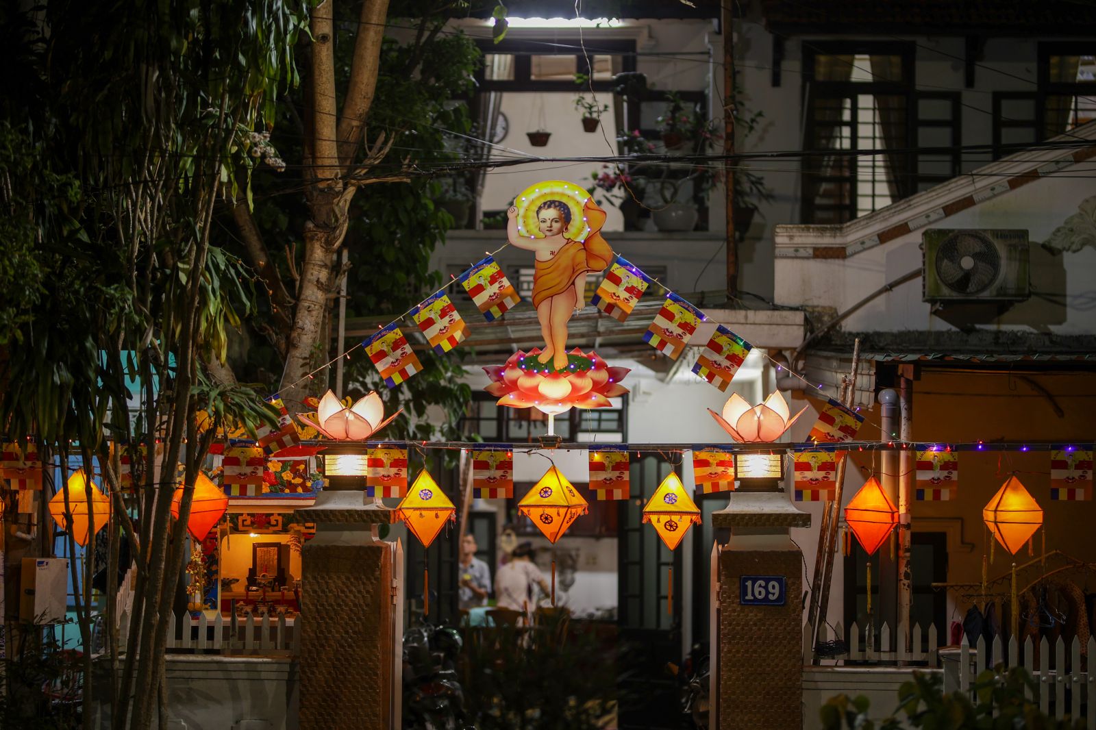 A family on Le Duan Street decorating stage to welcome Vesak
