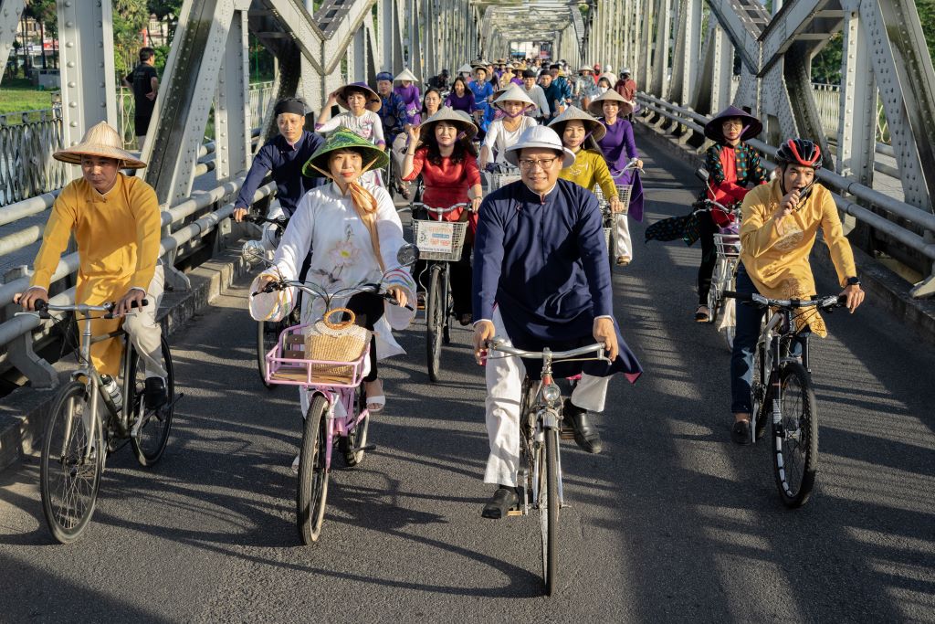 The delegation riding in single file through Truong Tien Bridge