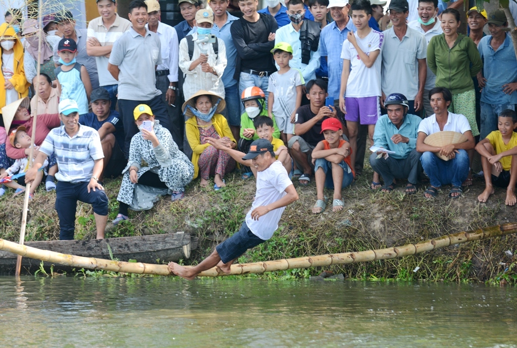 The game going on the monkey bridge on Nhu Y River is not less humorous than others when it requires both courage and ingenuity in balancing from the players