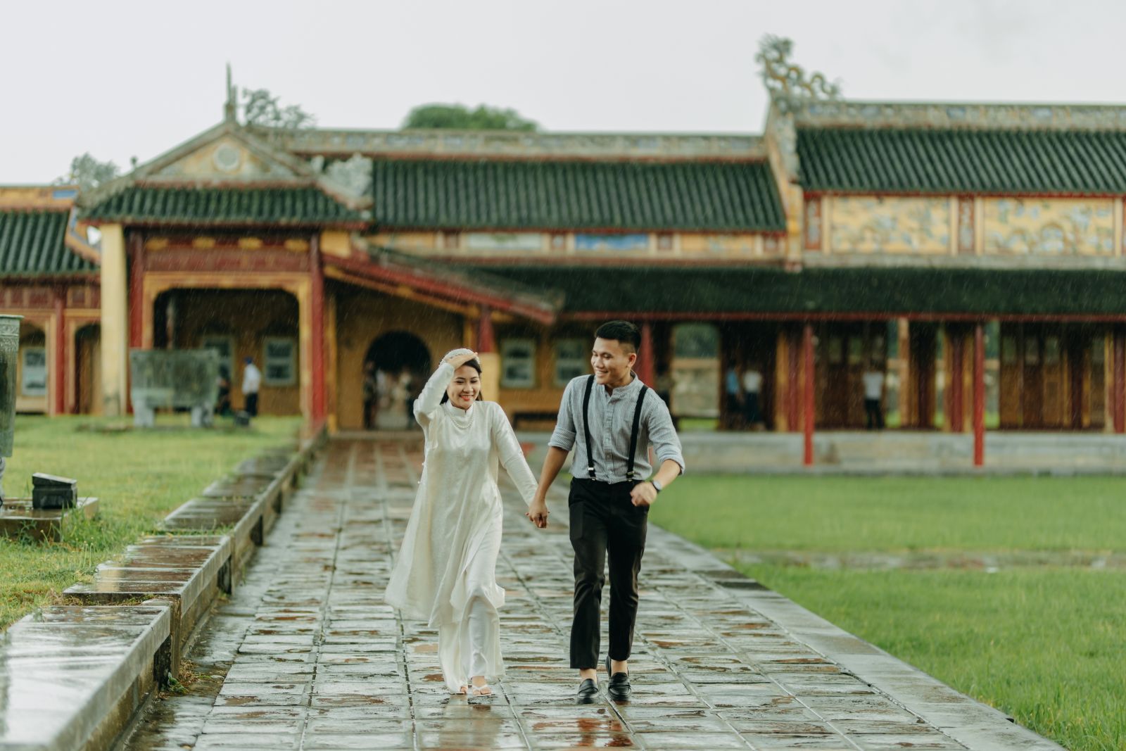 A couple in Hanoi chooses the backdrop of the Imperial Citadel in the rain to take their wedding photos