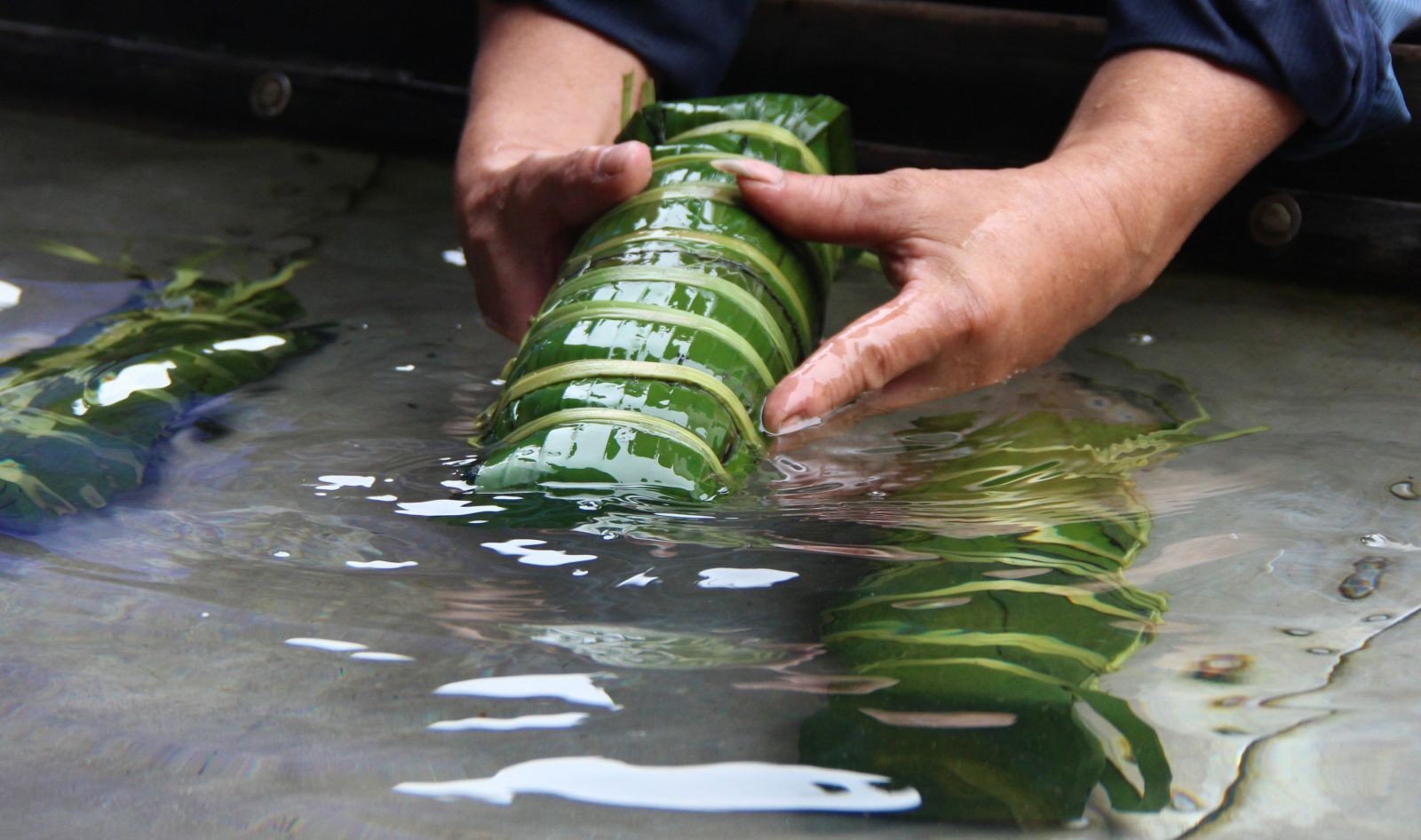 Both banh Chung and banh Tet are soaked in cold water after taking out from the pot