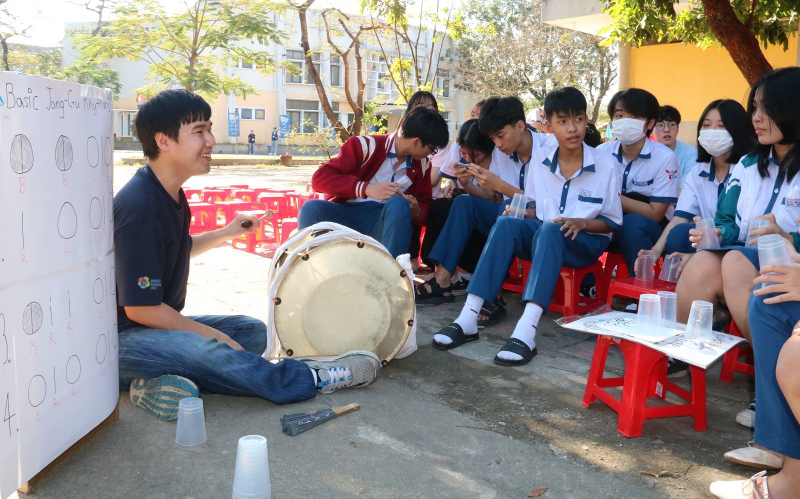 A Korean student guiding students from Thuan Hoa High school to play Korean instruments