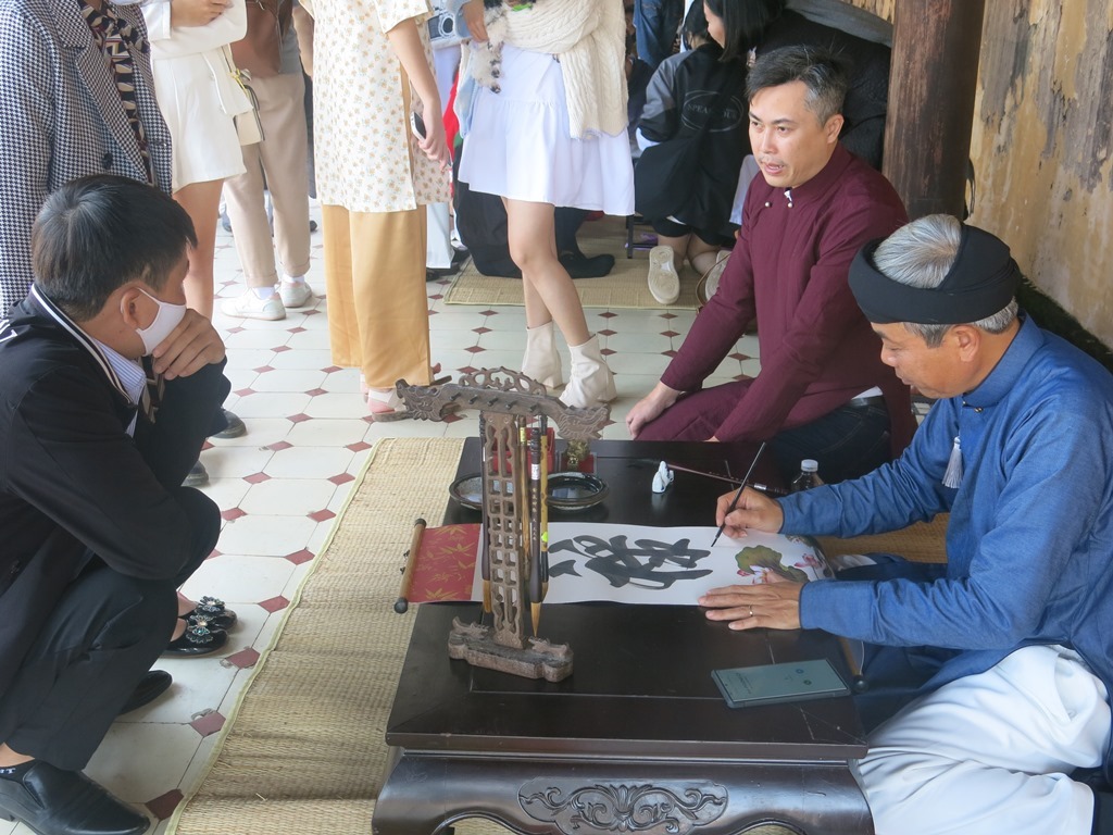 ​  Visitors receiving the new year gifts from Mr. Nguyen Phuoc Hai Trung, a calligrapher